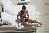 Helena Christensen in purple bikini and topless at the pool in Miami